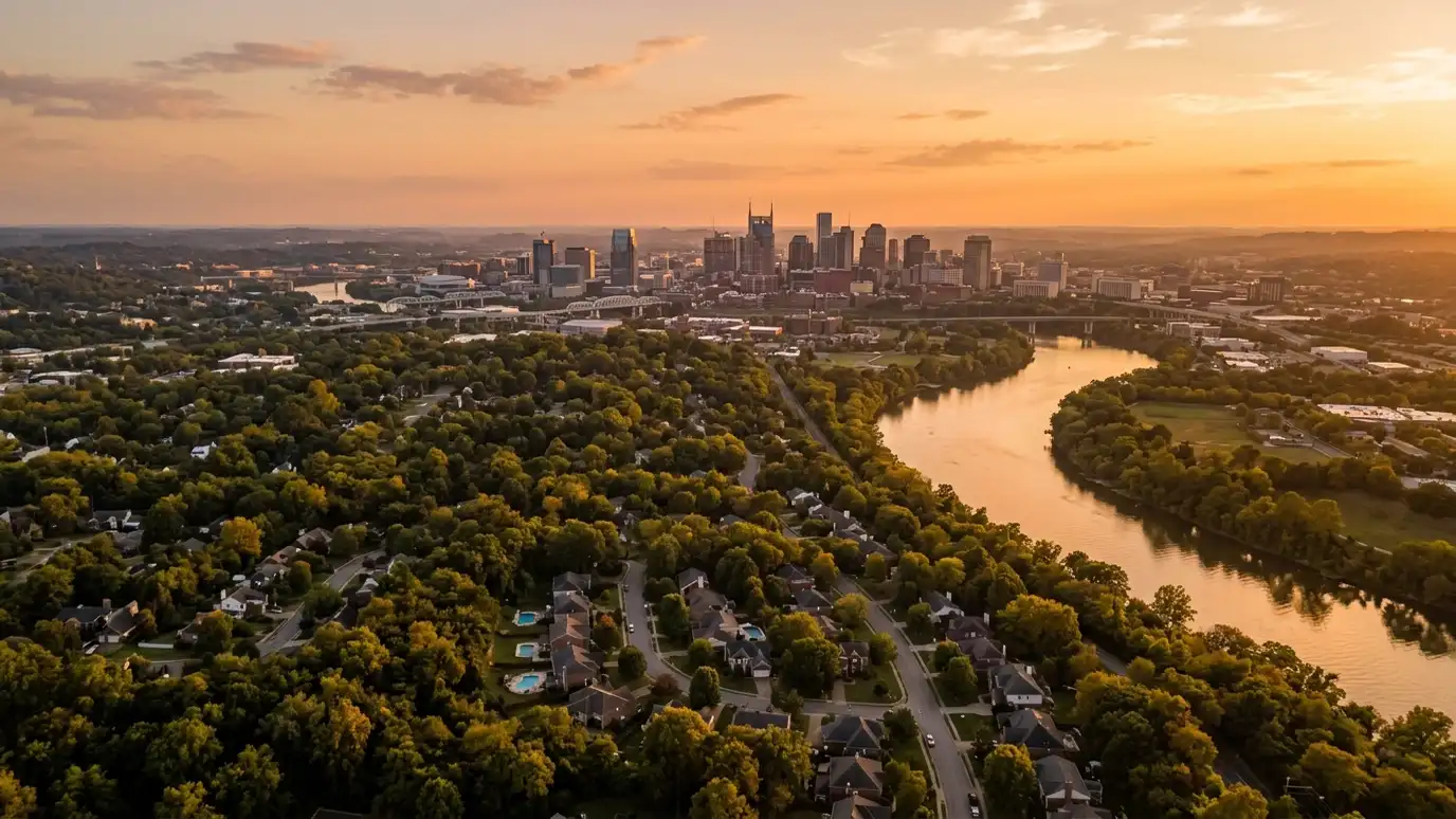 Window treatment service areas | Nashville and Middle Tennessee A golden sunset aerial view of the Nashville skyline above tree-covered neighborhoods with suburban homes and a winding river, warm evening light